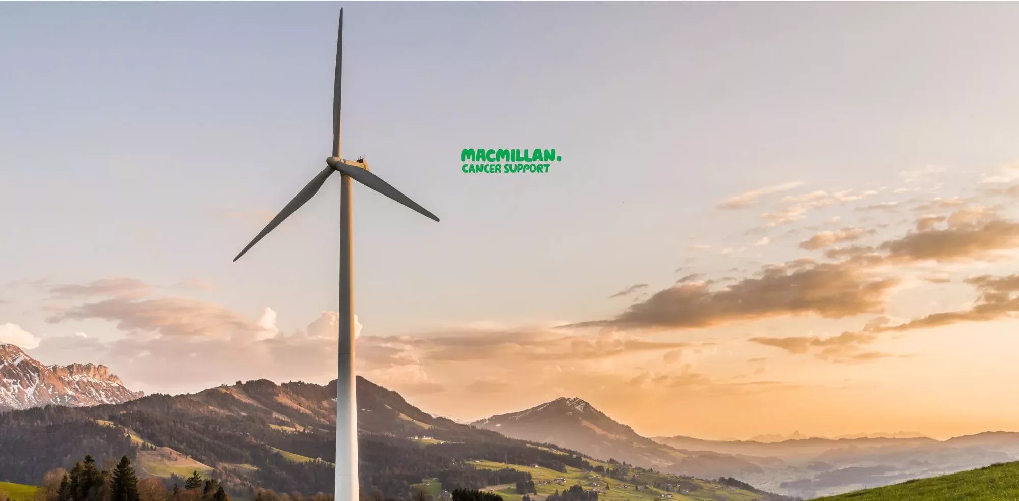 Charities - Macmillan Support Logo Displayed Over An Image Of Rolling Hills And A Wind Turbine