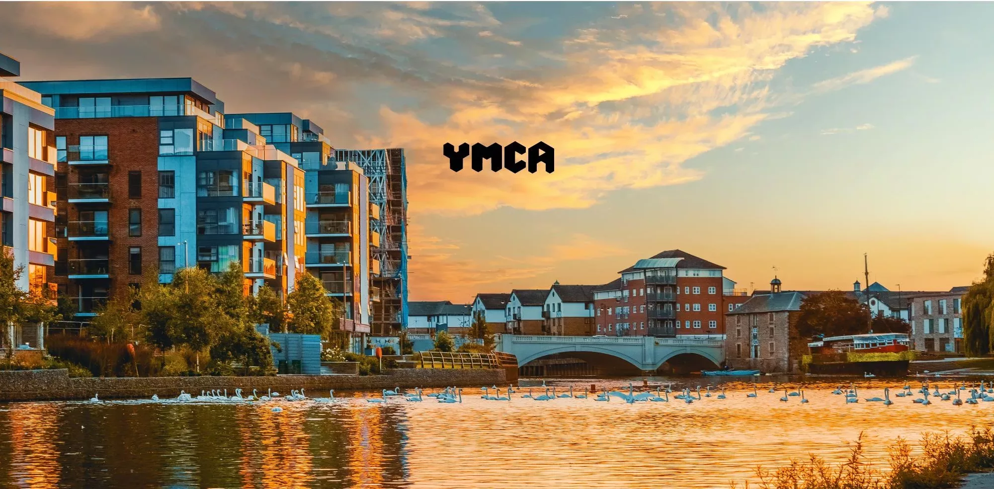 Charities - The YMCA Logo Displayed On An Image Of The River That Runs Through Peterborough