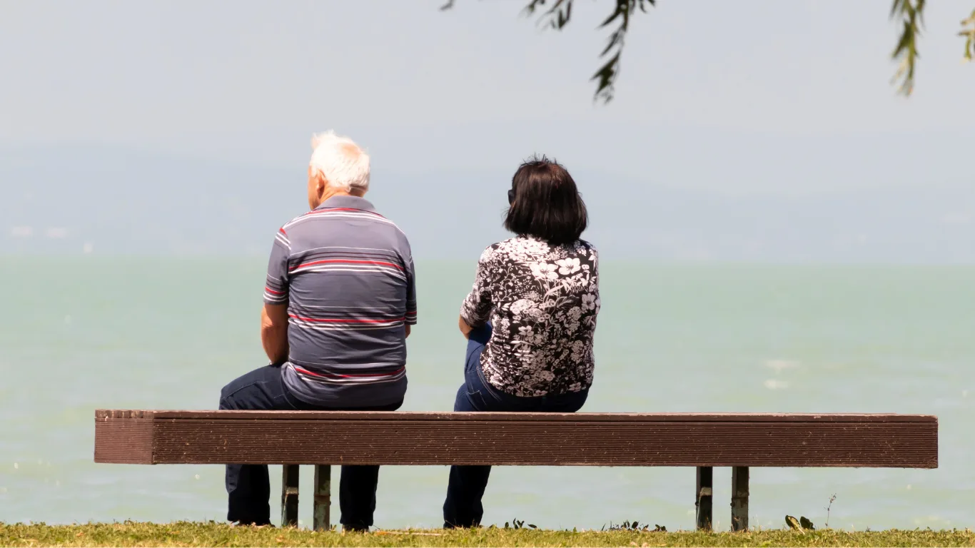 State pension vs personal tax threshold - image of older couple sitting on bench