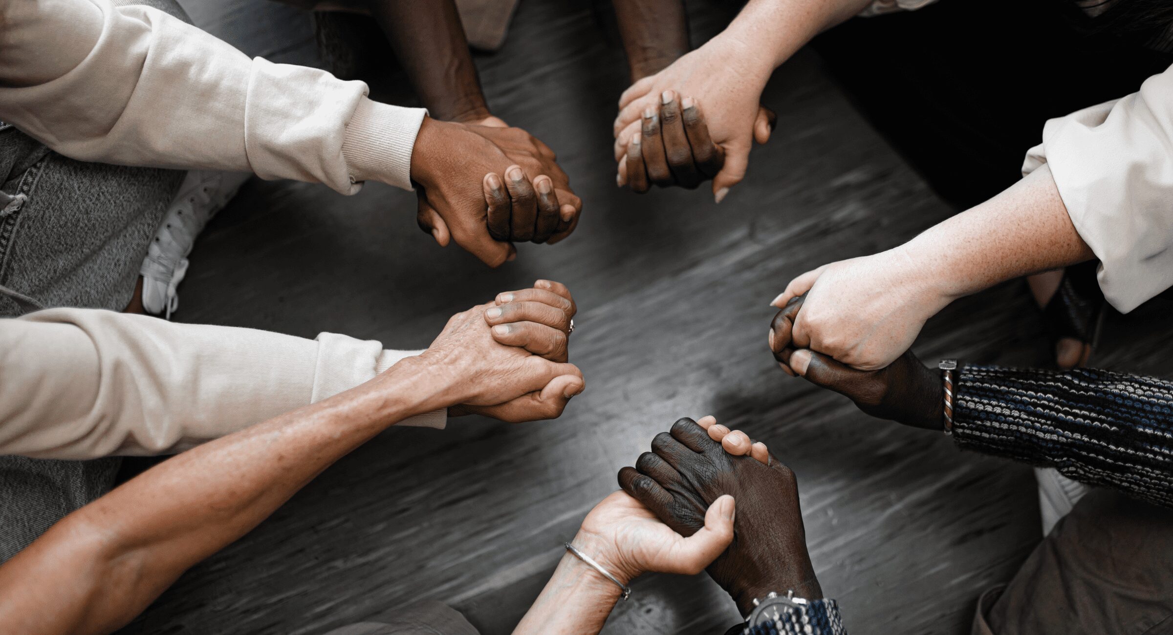 A photo of a team with their hands together to show our teams community commitment
