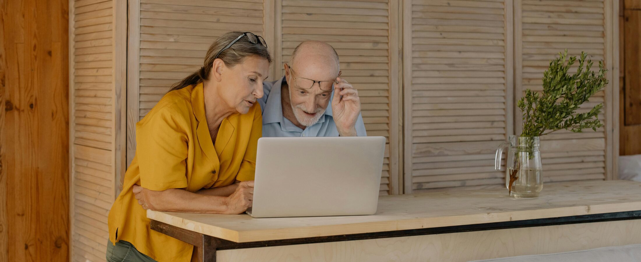 News & resources - an older couple looking at a computer screen at Henson Crisp's resources