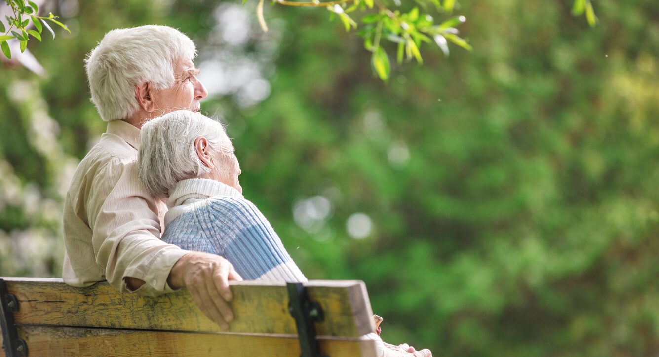 Couple sitting on a bench discussing state pension reform