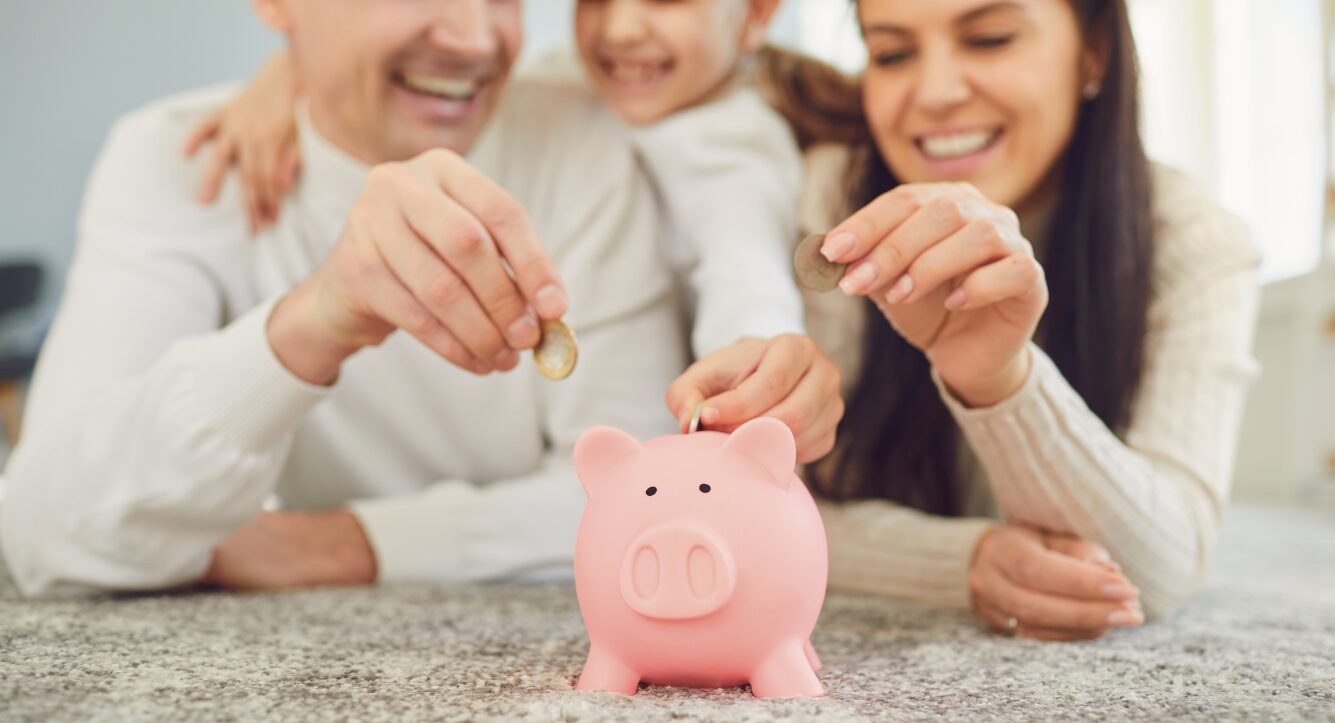 A family putting coins in a piggy bank saving up for their child trust funds